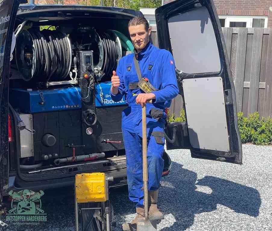 Een tevreden monteur met opgestoken duim naast de bestelbus, slim ingrijpen bespaart kosten bij een verstopte afvoer in Hardenberg