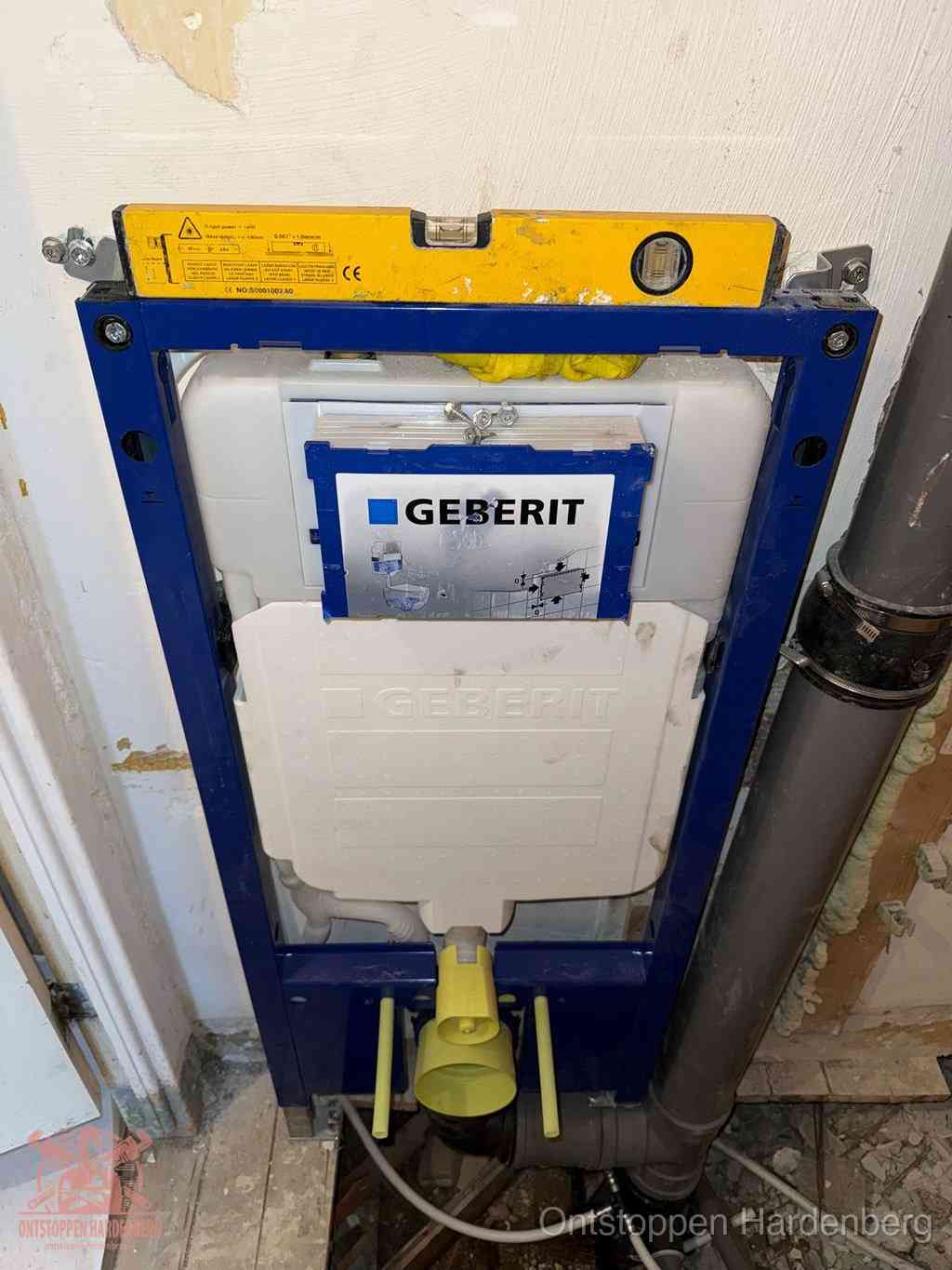 Een Geberit inbouwreservoir met frame voor een hangtoilet tegen de wand, met de afvoerbocht naar de vloer, kenmerkend voor een verstopt hangtoilet in Hardenberg