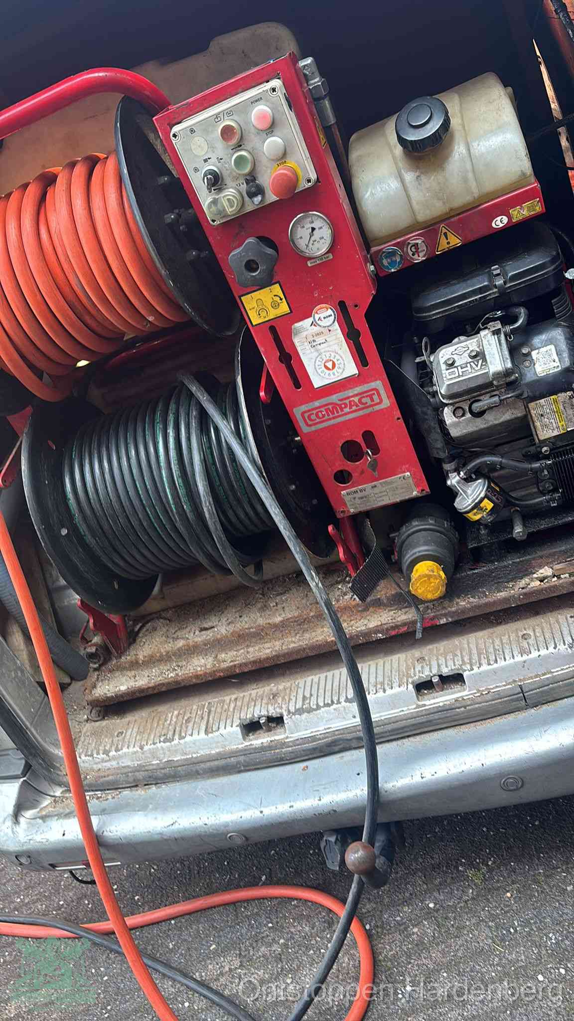 Een rood hogedruk-rioolreinigingstoestel in de laadbak van de bedrijfsbus, apparatuur voor een hardnekkige afvoerverstopping in Hardenberg