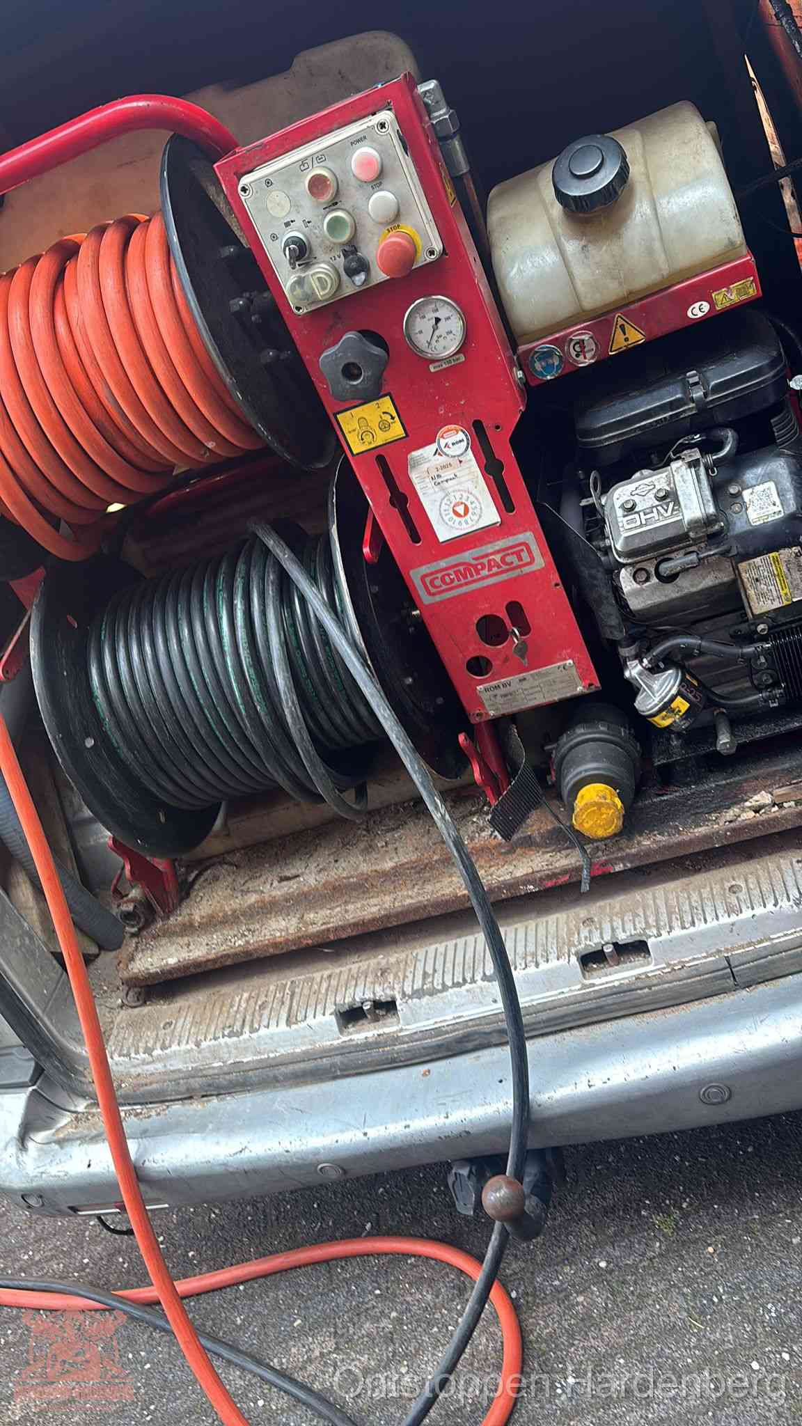 Een rood hogedruk-rioolreinigingstoestel met slangen in de laadbak van de bedrijfsbus, apparatuur voor een hardnekkige wc-verstopping in Hardenberg