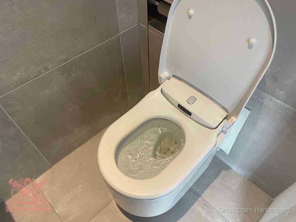 Een toiletpot vol troebel water met drijvend papier en restanten, de meest voorkomende oorzaak van een verstopte wc in Hardenberg