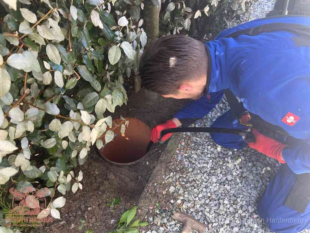 Monteur reinigt een rioolput met een slang, periodieke rioolreiniging in Hardenberg