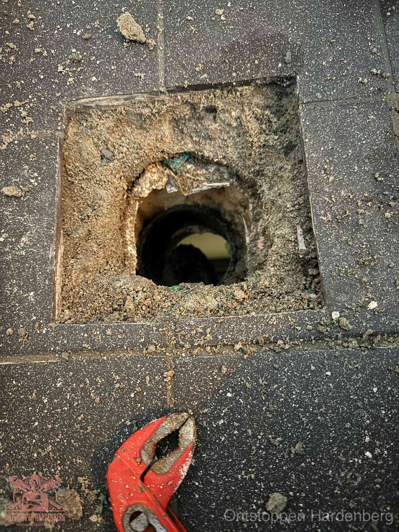 Geopend rioolputje op de erfgrens dat laat zien wie eigenaar is van de riolering in Hardenberg