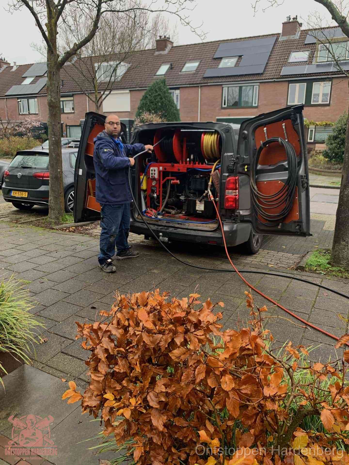 Monteur met rioolreinigingsbus levert rioolservice in de wijk in Hardenberg