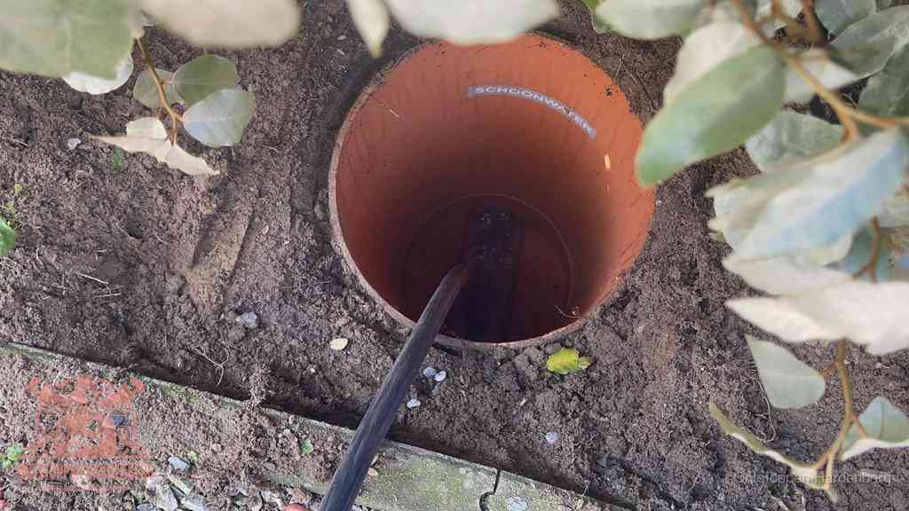 Open inspectieput in de tuin waar een veer rioolvliegjes en stankoverlast aanpakt in Hardenberg