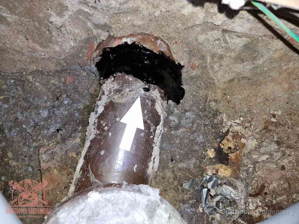 Een oude gres rioolbuis met een beschadigde koppeling onder de vloer, oorzaak van terugkerende structurele wc-problemen in Hardenberg