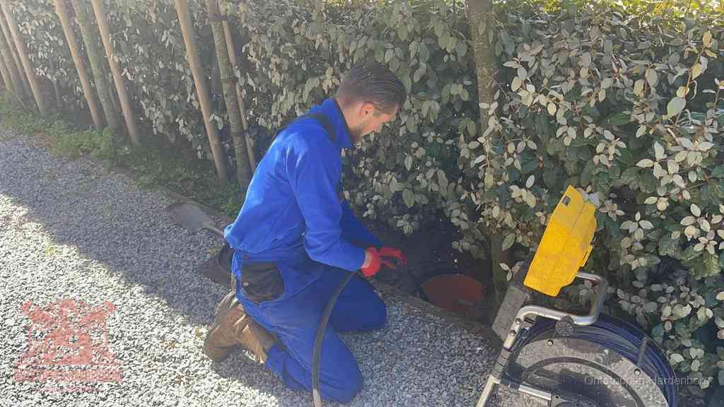 Monteur aan het werk bij een rioolput, de werkwijze voor riool ontstoppen in Hardenberg
